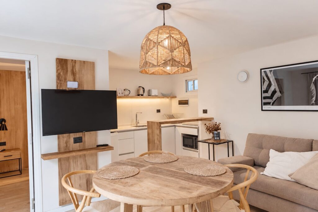 Ambiente integrado de un Deluxe Studio con mesa de comedor, cocina y sillón