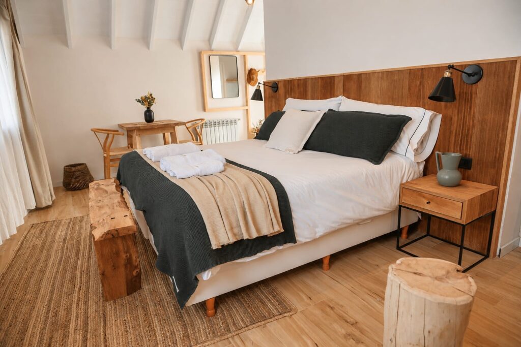 Dormitorio de un Deluxe Studio con cama matrimonial y mesas de luz de madera