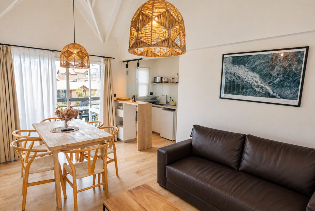 Living comedor de un departamento de 2 dormitorios con sofá cama y mesa para seis