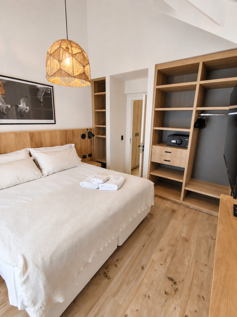 Cama matrimonial y placard abierto de un departamento de 1 dormitorio